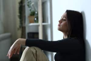 Adolescent sitting near wall, and she is suffering from mental health.