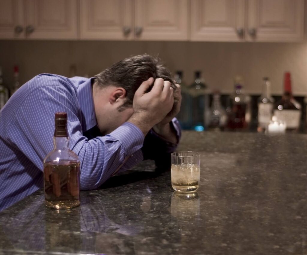 man drinking alcohol experiences withdrawal symptoms