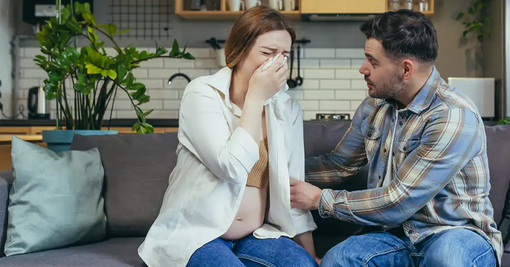 Partner providing emotional support to a pregnant woman struggling with her mental health