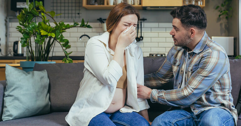 Partner providing emotional support to a pregnant woman struggling with her mental health