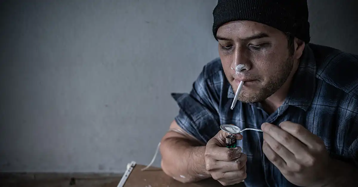 Person handling cocaine in a dimly lit setting, used to illustrate factors affecting cocaine metabolism, elimination, and detection times.