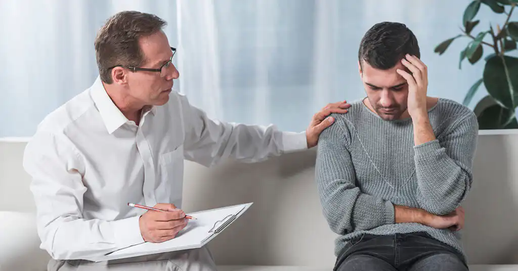 Mental health professional speaking with a client during a therapy session, illustrating the structured treatment and clinical support provided in a Partial Hospitalization Program (PHP)