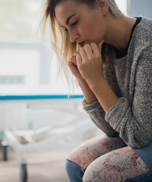 A woman sit on a hospital bed with anxiety. She was afraid of despair What she wants now is faith